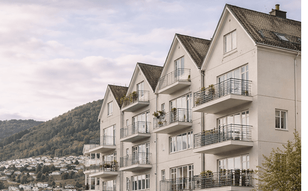 Moderne leilighetsbygg med utsikt mot grønn ås og boligområde i Bergen