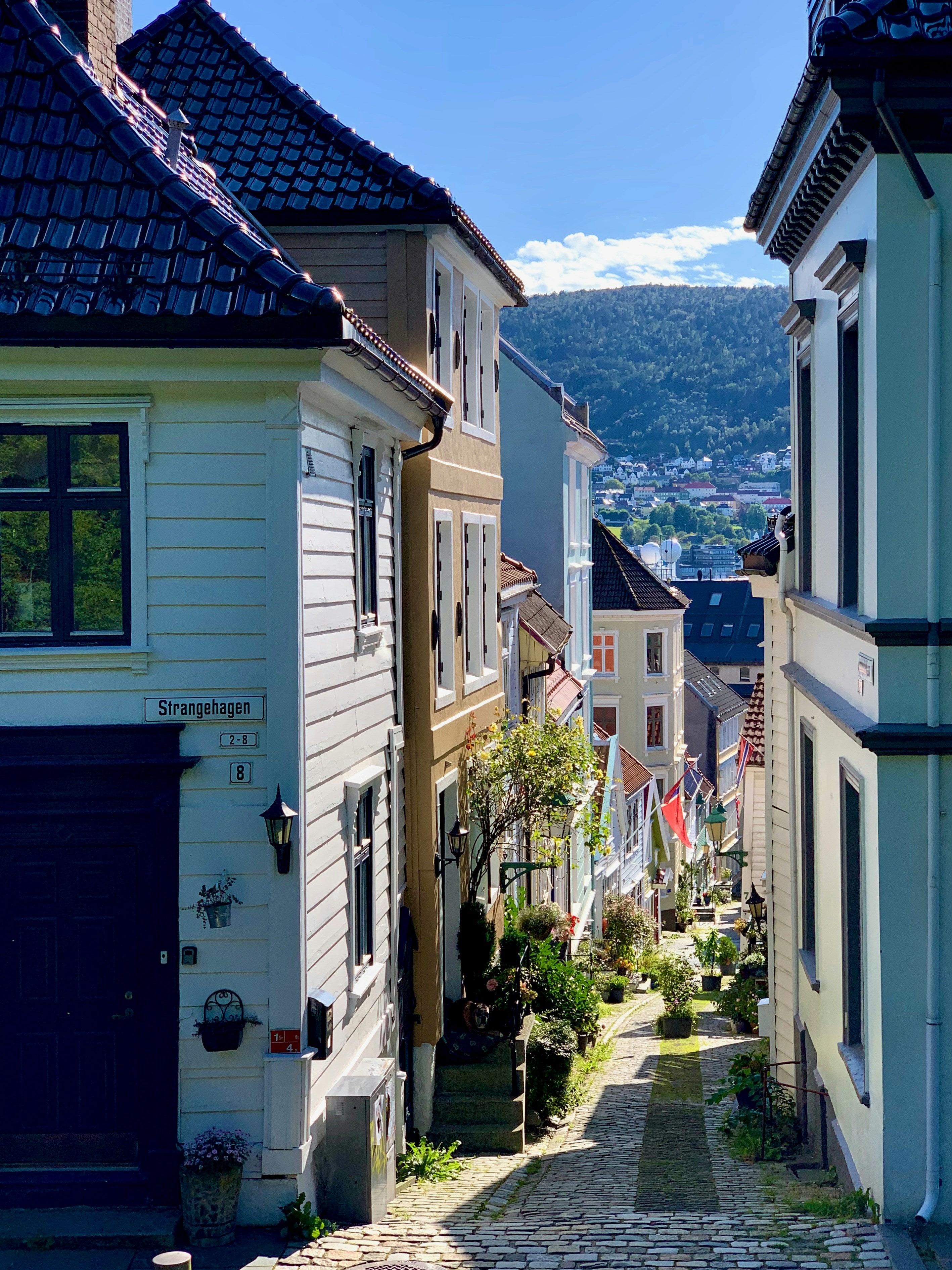 Smal gate med trehus i Bergen, skilt med «Strangehagen»